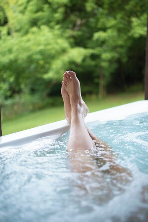 A foot in a hot tub with a blurred green background. - Biker Hiker INN at Strouds Run (Athens)