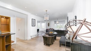 A spacious living area with a wooden floor, a sofa set, a round coffee table, and a modern chandelier. - ' Luxury & Spacious AirCondisioned 4 Bed 4 Bath Apartment ' (London)