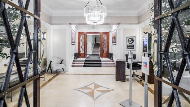A spacious lobby with a chandelier, a reception desk, and a staircase leading to another floor. - ' Luxury & Spacious AirCondisioned 4 Bed 4 Bath Apartment ' (London)