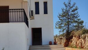 A modern two-story building with a concrete staircase leading to a dark entrance. - Chrisa's Beautiful Apartment  (Chania)