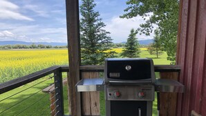 En Warthat-grill på ett trädäck med utsikt över ett fält och berg.