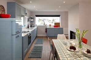 Oven, dishwasher, highchair, cookware/dishes/utensils - Stone’s Throw : Pet-Friendly 4‑Bed Bungalow Near Beach in Rhosneigr | Managed by Anglesey Holiday Le (Rhosneigr)