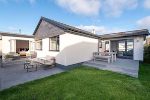 A modern house with a patio, a dining area, and a garage. - Stone’s Throw: A pet-friendly holiday bungalow in Rhosneigr (Rhosneigr)