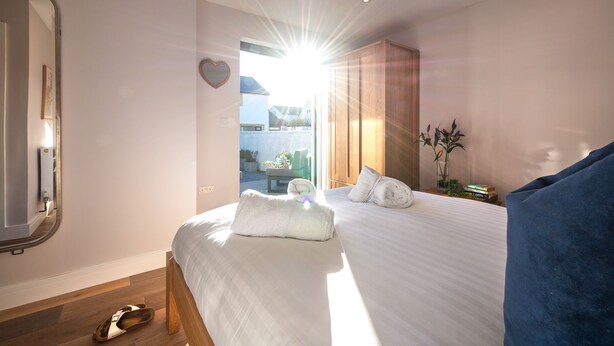 Quarto de hotel com uma cama grande, área de estar e vista para o exterior.