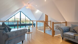 Un loft spacieux avec de hauts plafonds, de grandes fenêtres et un plancher en bois.
