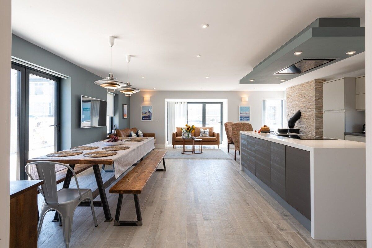 Fully equipped kitchen with electric hob, oven, dishwasher and wine fridge, open-plan self-catering group holiday home 50 metres from the beach in Rhosneigr, Anglesey