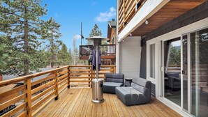 A wooden deck with outdoor seating and a trash can. - CRESCENT TREE CABIN CLOSE TO BEAR MOUNTAIN, GOLF COURSE  AND THE ZOO (Big Bear Lake)