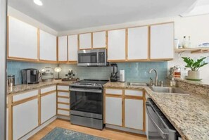 Enjoy cooking in this well-equipped kitchen with a central island, oven, and microwave.