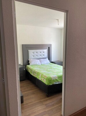 Cozy retreat with a single bed, tufted headboard, and comfortable nightstand.