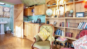 A cozy room with wooden furniture, a globe, bookshelves, and a vintage chair. - The Observatory-UK41754 (Tresawson, near Looe)