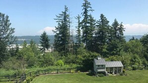 A house with a fenced yard and a view of tall trees and distant mountains. - Edgewood Escape | Mt. Rainier View| EV Charger - Central (Edgewood)