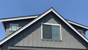 A two-story house with a garage, a small window with shutters, and a stone foundation. - Edgewood Escape | Mt. Rainier View| EV Charger - Central (Edgewood)