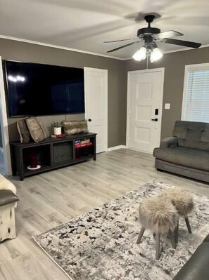 Relax in this stylish living room with a flat-screen TV, entertainment unit, and plush sofa.