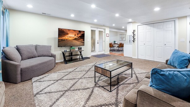 A living room with a sofa, a coffee table, and a TV on a stand. - Private/clean guest suite, bath, kitchen & laundry (South Jordan)