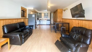 A spacious living area with two black leather sofas, a wooden dining table, and a kitchen in the background. - Awesome Location Steam Shower Hottub (Telluride)
