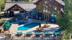 Un resort con piscina, mobiliario exterior y un edificio grande de madera.