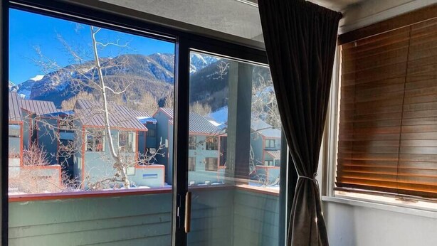 Un balcone con vista su case e montagne.