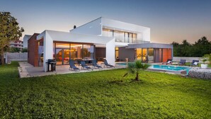 A modern two-story house with a swimming pool, outdoor seating, and a well-maintained lawn. - Luxury Villa Borealis with Pool (Ližnjan)