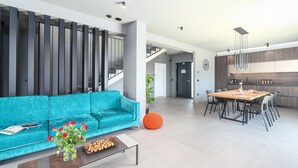A modern living room with a teal sofa, a coffee table with a tray of nuts, and a vase of red roses. - Luxury Villa Monroe with Pool (Vodnjan)