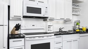 A modern kitchen with white cabinetry, a built-in microwave, a stove, and a coffee maker. - 3BD/Vegas - Kitchen, Margarita Mixer, and Parking! (Las Vegas)