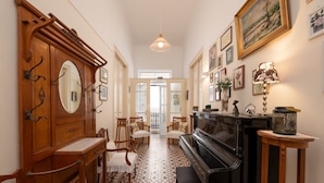 A hallway with a piano, wooden furniture, and a mirror. - Mary's Central Beachside Mansion- with large Terrace and Balcony  (Agios Nikolaos)