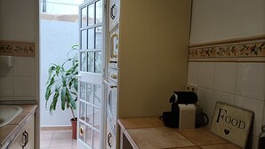 Une cuisine avec une porte blanche, une plante en pot et un panneau indiquant « Pour les gourmets ».