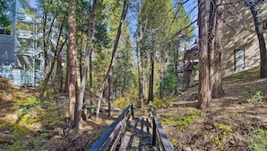 A wooden bridge in a forested area with buildings in the background. - Pet-Friendly Retreat w/ Game Room & Fire Pit! (Lake Arrowhead)