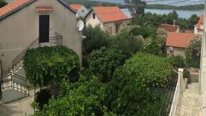 A residential area with houses, a satellite dish, and a staircase leading to a balcony. - The whole Mario's house for rent (Jelsa)