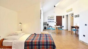 A room with a bed, a dining area with chairs and a table, and a kitchenette in the background. - The whole Mario's house for rent (Jelsa)