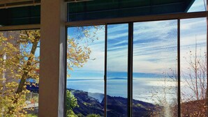 A window with a view of a mountainous landscape and a body of water.