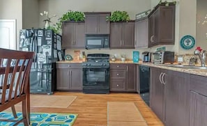 A kitchen with dark cabinets, a microwave, a stove, and a dishwasher.