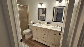 Een bad/douchecombinatie, een haardroger, handdoeken, toiletpapier