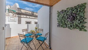 A balcony with a table, chairs, and a potted plant. - Home2Book Charming Attic Arucas Center, Terrace (Arucas)