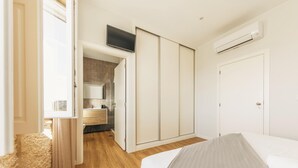 A bedroom with a bed, a wardrobe, a TV, and an air conditioning unit. - Casa do Desassossego  (Monção)
