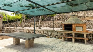 An outdoor patio with a stone bench and a brick oven. - Casa do Desassossego  (Monção)