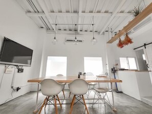 Una cocina moderna con armarios blancos, encimera de madera y una planta colgante.