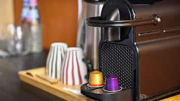 Une machine à café avec une carcasse noire et un manche métallique.