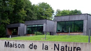 Un edificio moderno con un cartel que dice "Maison de la Nature".