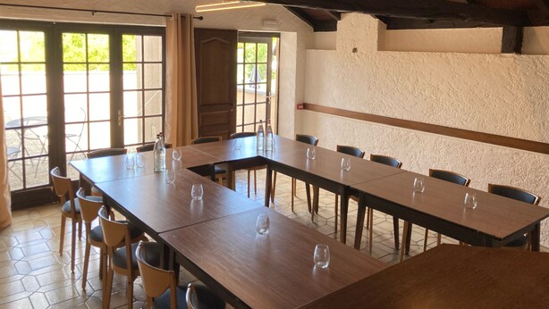 A spacious dining area with long wooden tables and chairs, large windows, and a rustic ceiling. - Relais Manderen (Manderen-Ritzing)