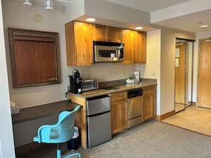 A compact kitchen with wooden cabinets, a microwave, a toaster, and a dishwasher. - Walk to the Slopes - Heated Pool & Hot Tub - King Bed - Sleeps 4 (Crested Butte)