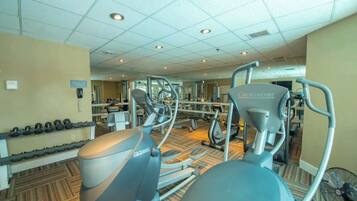 Un gimnasio con cintas de correr, elípticas y pesas sueltas.