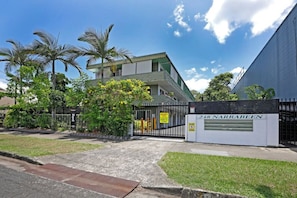 248 Narabeen features a gated entrance surrounded by lush greenery and palm trees.
