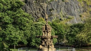 Eine historische Burg auf einem Hügel mit einem zentralen Brunnen.