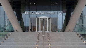 The entrance to NH IQUIQUE PACIFICO with a glass facade and a revolving door. - NH Iquique Pacifico (Iquique)