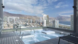 A rooftop pool with a city view, including mountains and a beach. - NH Iquique Pacifico (Iquique)