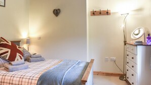 Une chambre à coucher avec un lit, des lampes de chevet, une commode et un miroir.
