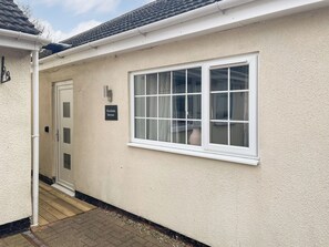 A building with a white exterior, a door with a frosted glass panel, and a window with white framing. - Woodside Retreat, Number 37 (Newbold Coleorton)