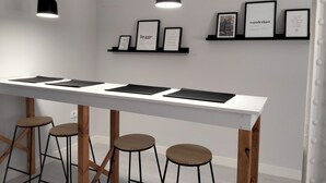 A modern bar area with a white countertop, black stools, and pendant lighting. - Double room in the heart of the old town of La Nucía (La Nucía)