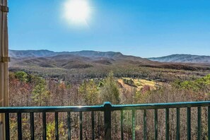 A mountain landscape with a clear sky and a view from a balcony with a green railing. - Nature Views Pool Access Mountain Hideaway (Gatlinburg)