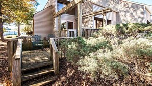 Ein modernes Haus mit einer Holzterrasse und einer überdachten Veranda.